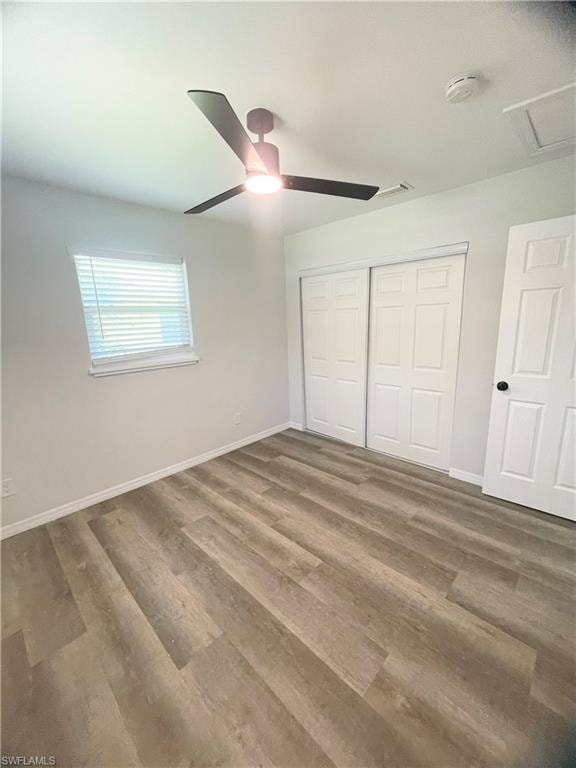 Spacious room featuring wood-finish flooring, a contemporary ceiling fan with integrated lighting, a window with blinds, and white bi-fold closet doors