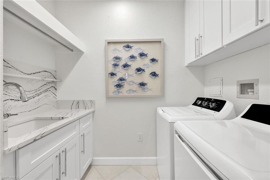 Laundry room offers plenty of storage...featuring quartz countertops and shaker cabinets.