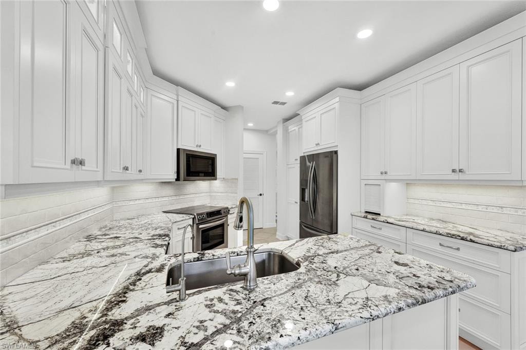 Completely renovated kitchen features quartzite countertops and stainless appliances.