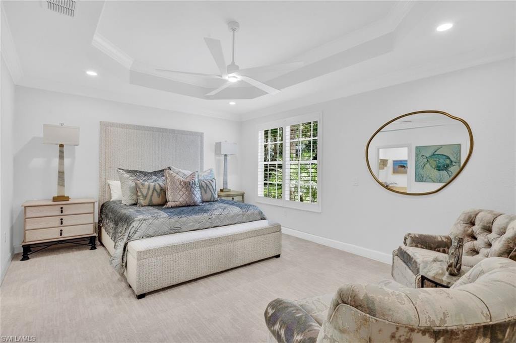 Primary bedroom with plenty of space and tray ceilings.