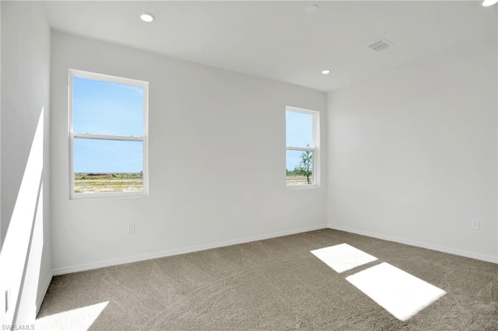 Unfurnished room with light colored carpet and recessed lighting