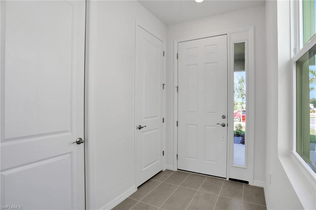 Foyer entrance with light tile patterned floors and recessed lighting