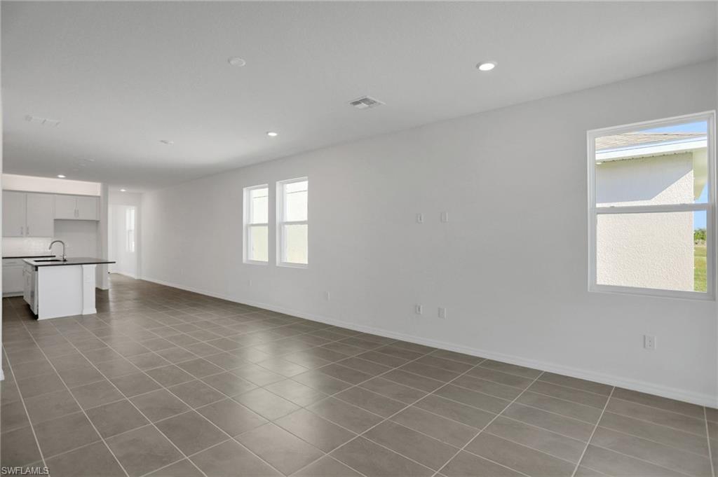 Unfurnished living room featuring recessed lighting and light tile patterned floors