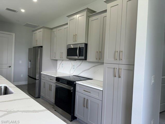 Empty room with a raised ceiling, ceiling fan, light wood-style floors, recessed lighting, and ornamental molding