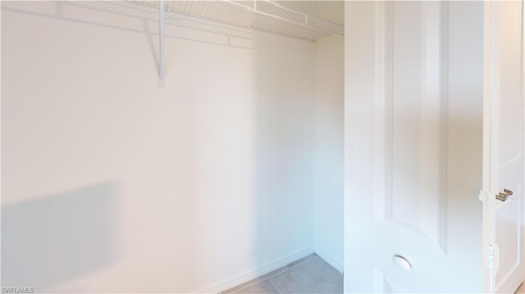 Walk-in closet featuring white wire shelving and light-colored wall-to-wall carpeting