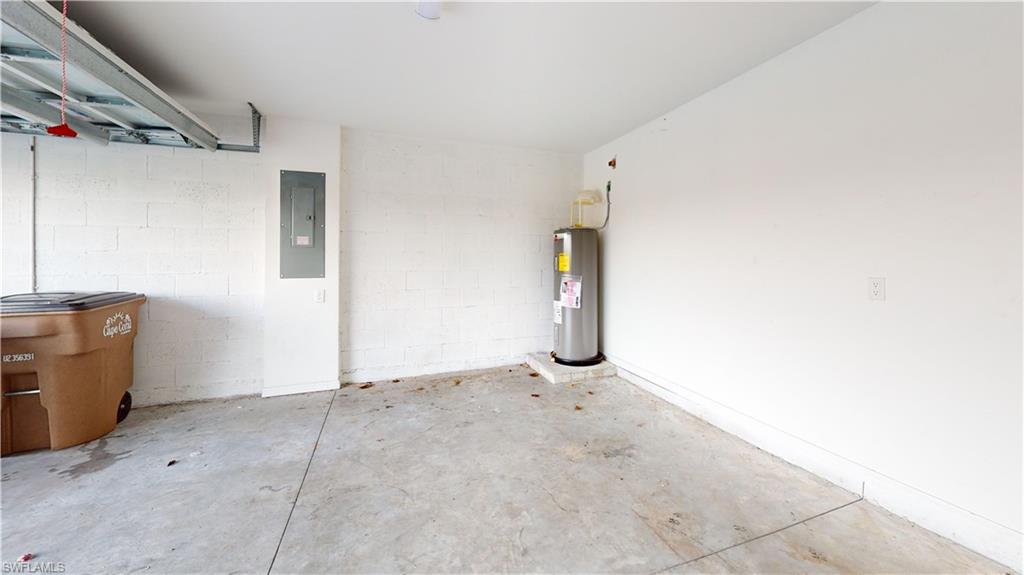 Utility room featuring a water heater, concrete flooring, painted block walls, and an electrical panel