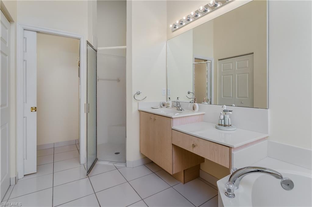 Built-in makeup vanity, large wall mirror, and walk-in shower with glass enclosure