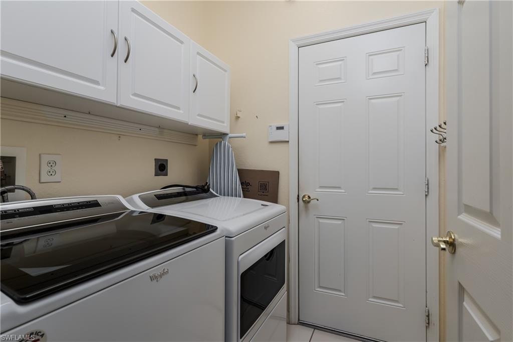 White shaker-style cabinetry with brushed nickel hardware, light-toned wall paint, and a paneled interior door with a brass-finish knob