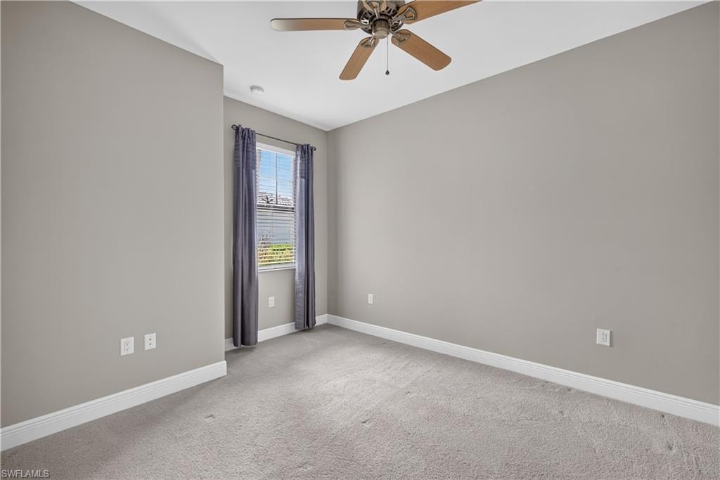 Guest bedroom featuring a window with blinds, curtains, ceiling fan, and light gray wall paint