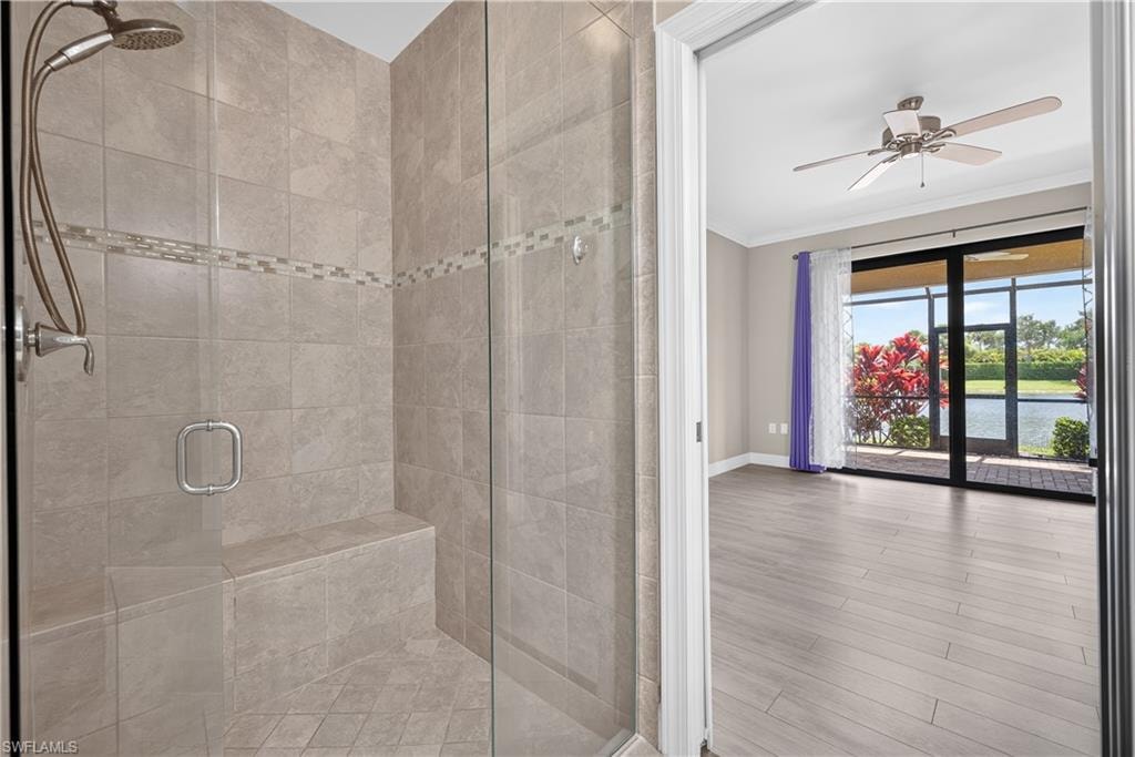 Water views from the primary bathroom.  A walk-in shower with neutral-toned tiling, listello,  integrated bench seating and frameless glass door.
