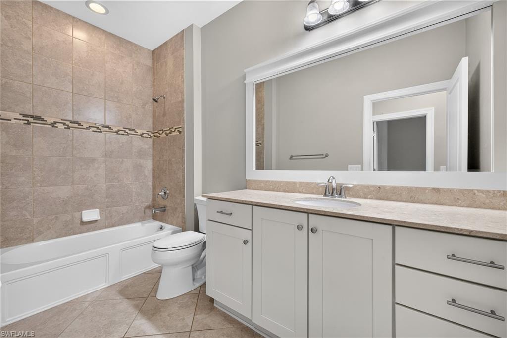 Bathroom featuring a white vanity with slab countertop, undermount sink, and brushed nickel fixtures