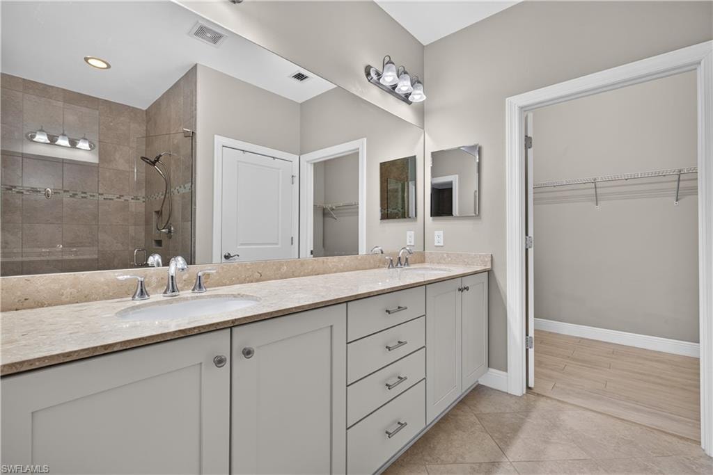 Dual vanity with undermount sinks, light-toned Verona stone countertop, and white cabinetry