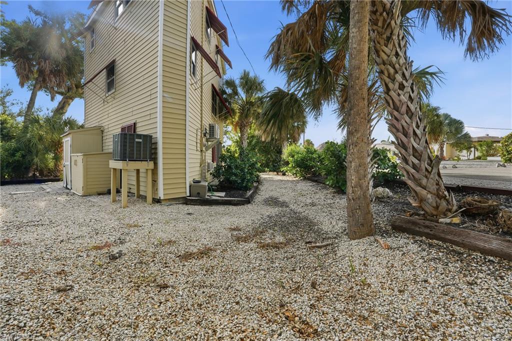 View of side of property featuring a central air condition unit and a garage - Virtually Edited Image