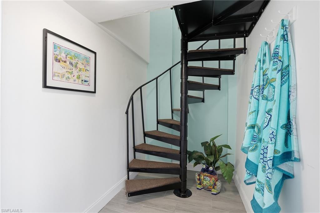 Black spiral staircase featuring carpeted treads and a metal railing system - Virtually Edited Image