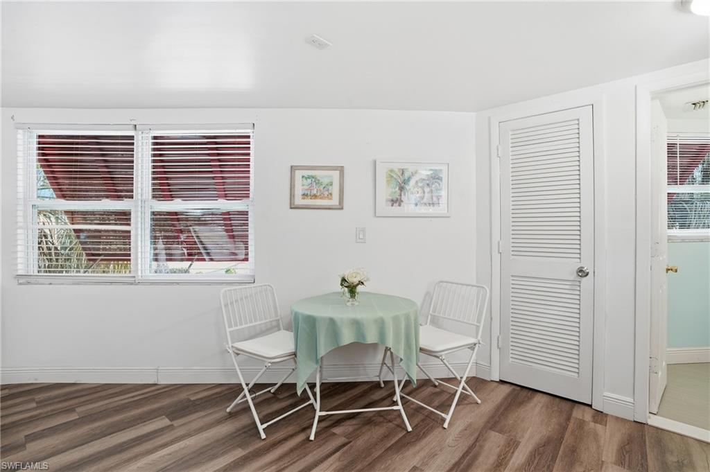 Wood-finish flooring throughout, bright white walls, and a louvered interior door - Virtually Edited Image