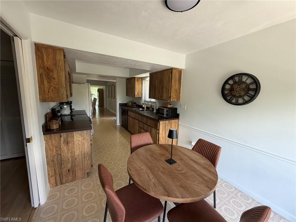 Kitchen with wood-finish cabinetry, dark countertops, and patterned floor tile
