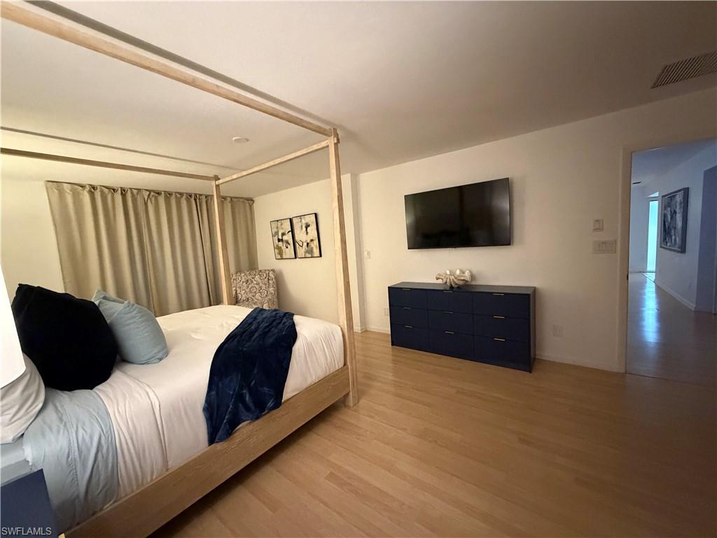 Recessed ceiling lighting, wood-finish flooring, and a wide entryway