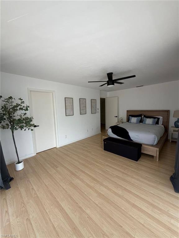 Spacious room featuring light wood-finish flooring and a contemporary black ceiling fan
