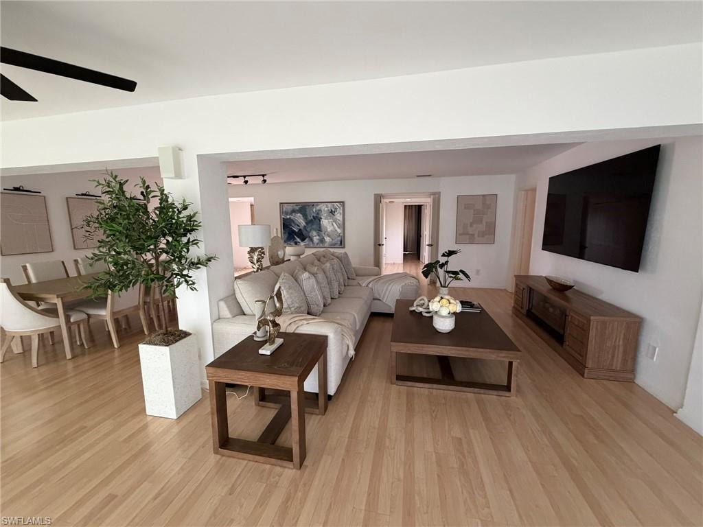 Spacious living area featuring light wood-finish flooring and recessed lighting