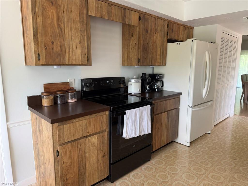 Kitchen space featuring wood-finish cabinetry and dark countertops