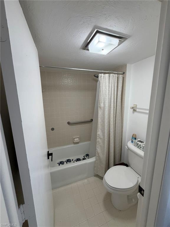 Bathroom featuring a white tub, light-colored tile surround, and a coordinating floor