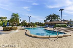 Resort-style pool area featuring a freeform swimming pool, integrated spa, and expansive paver deck