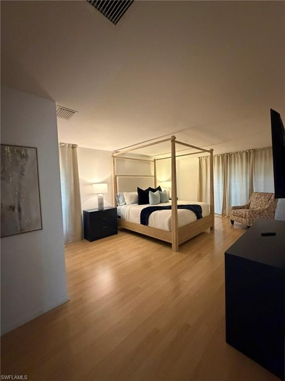 Spacious room featuring wood-finish flooring, white walls, and recessed lighting