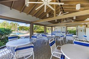 Open-air pavilion featuring a vaulted wood-beam ceiling, ceiling fans, recessed lighting, and a paved patio