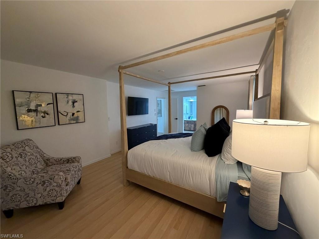 Bedroom featuring light wood-finish flooring, white walls, and a recessed ceiling