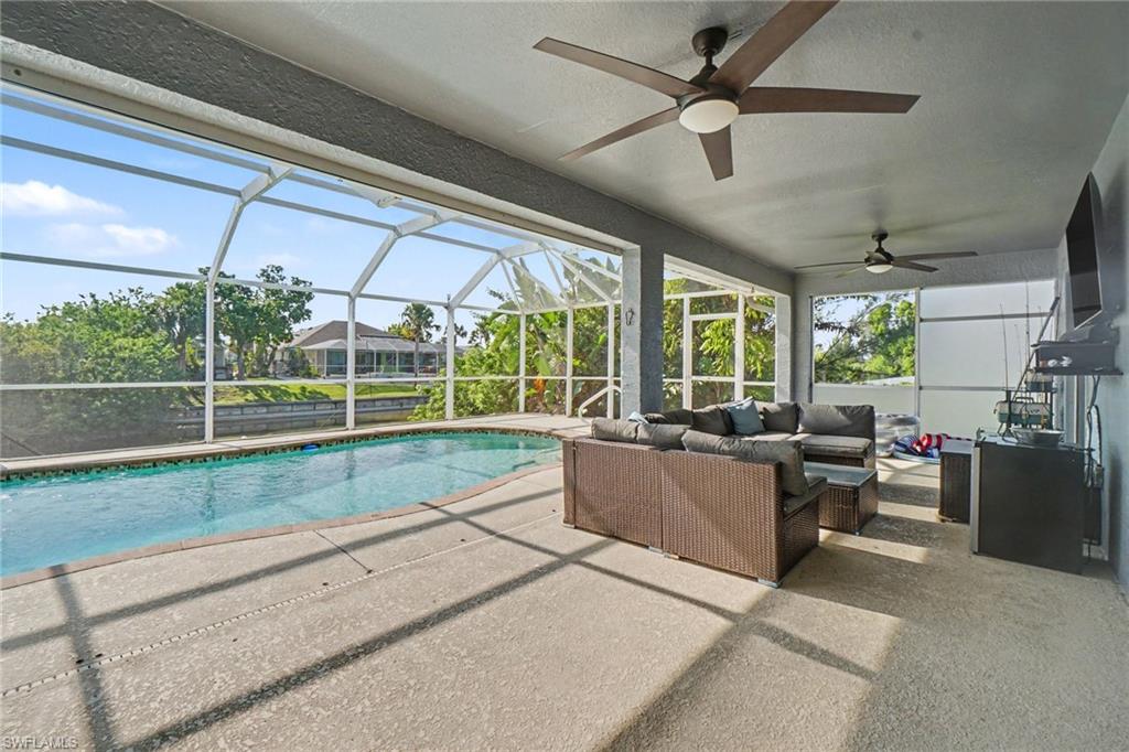 Screened lanai featuring a swimming pool, textured concrete deck, and multiple ceiling fans