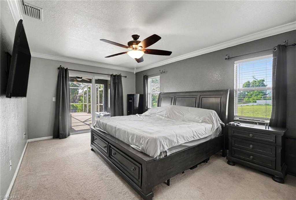 Spacious room featuring light-colored carpet, a ceiling fan with integrated lighting, and crown molding