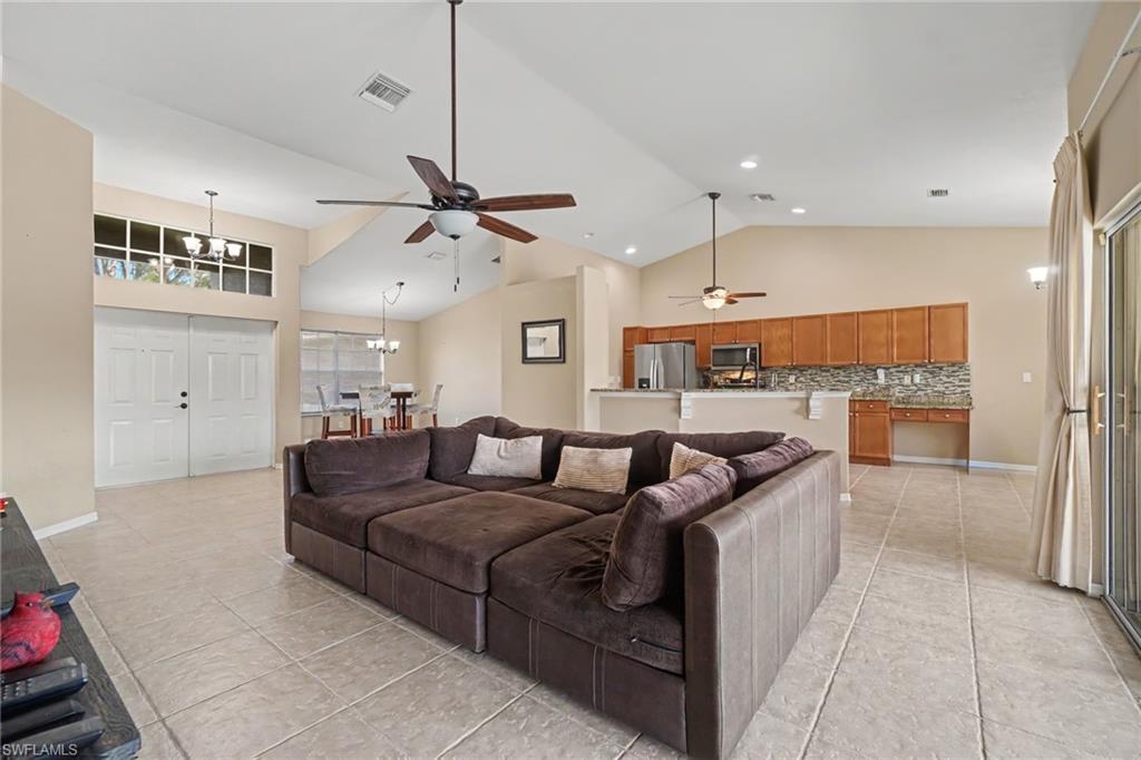 Vaulted ceilings enhance this open-concept living area featuring tile flooring throughout