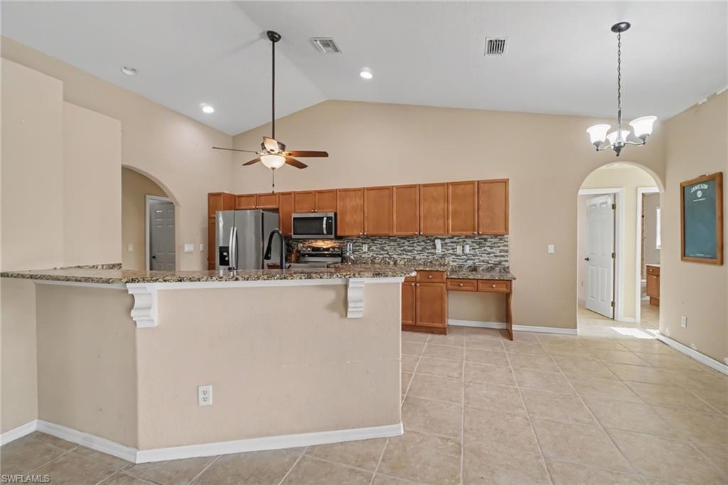 Kitchen and dining area featuring vaulted ceilings, ceiling fan, and recessed lighting
