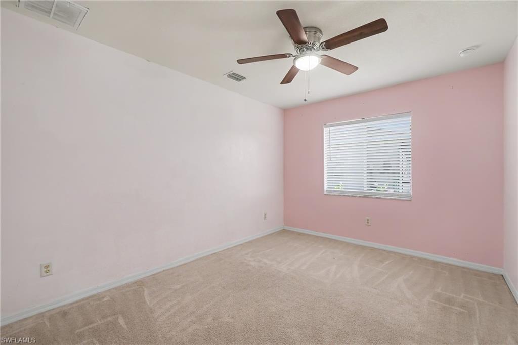 Room featuring light pink walls and neutral carpet flooring