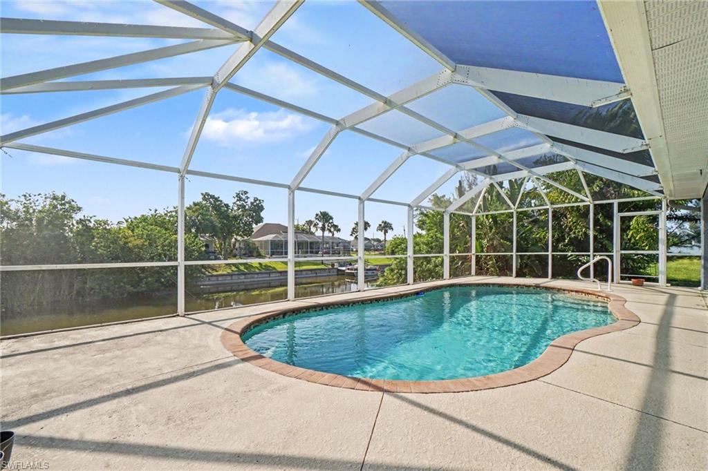 Screened pool enclosure with a freeform pool and spacious concrete decking