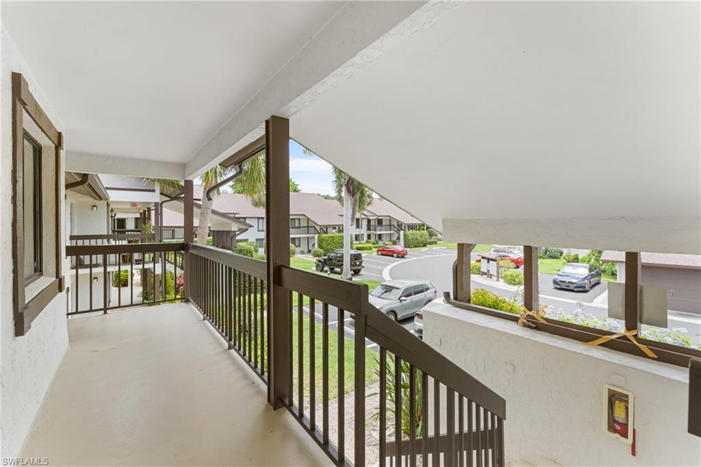 Exterior porch with concrete flooring and dark wood-tone railings