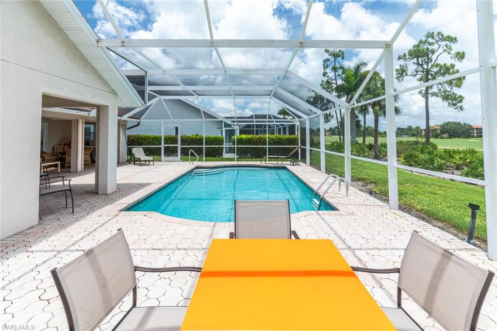 Outdoor pool with a patio, a sunroom, glass enclosure, and a yard