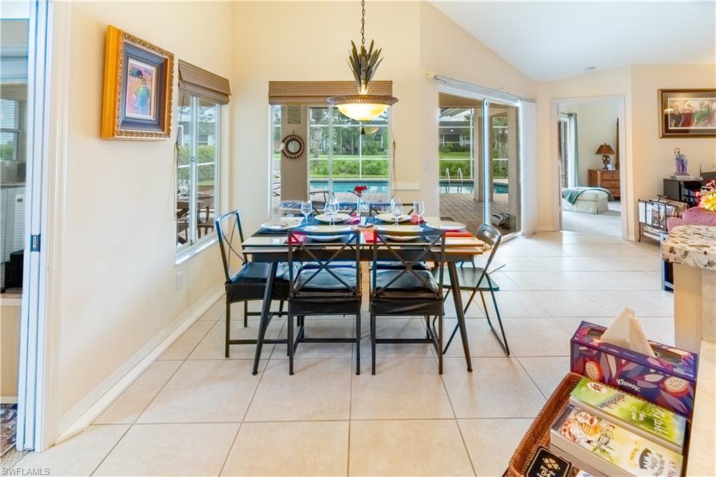Dining area featuring light tile patterned flooring and high vaulted ceiling