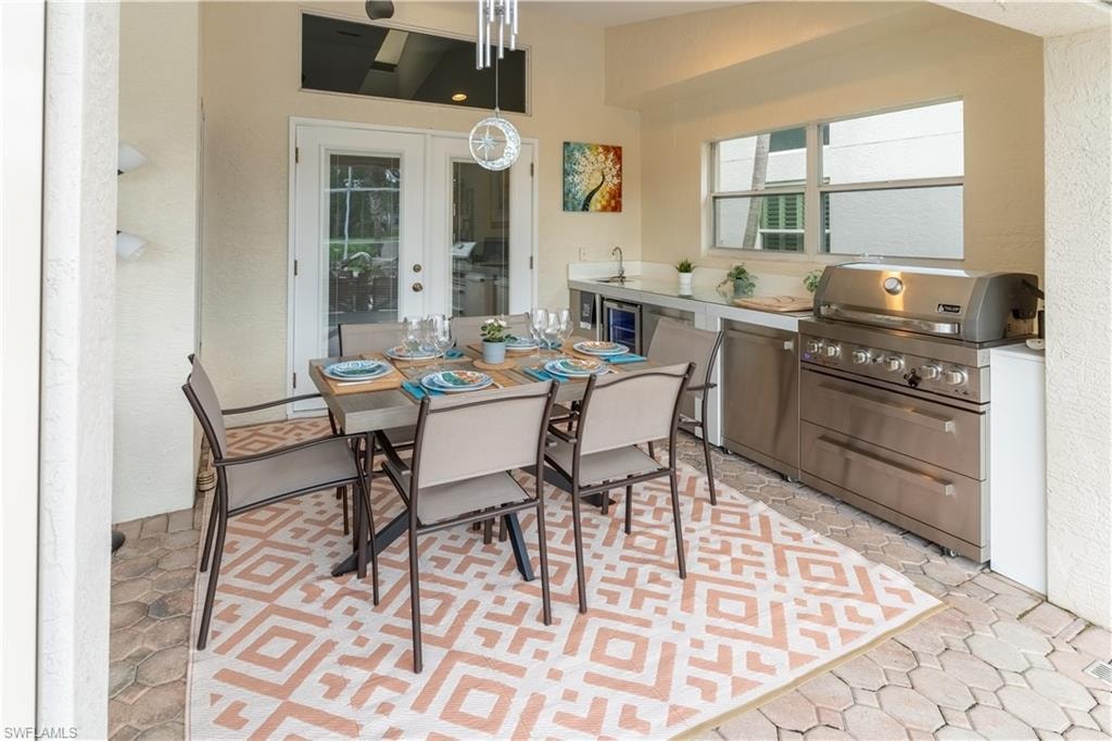 Dining room with french doors, a textured wall, and wine cooler