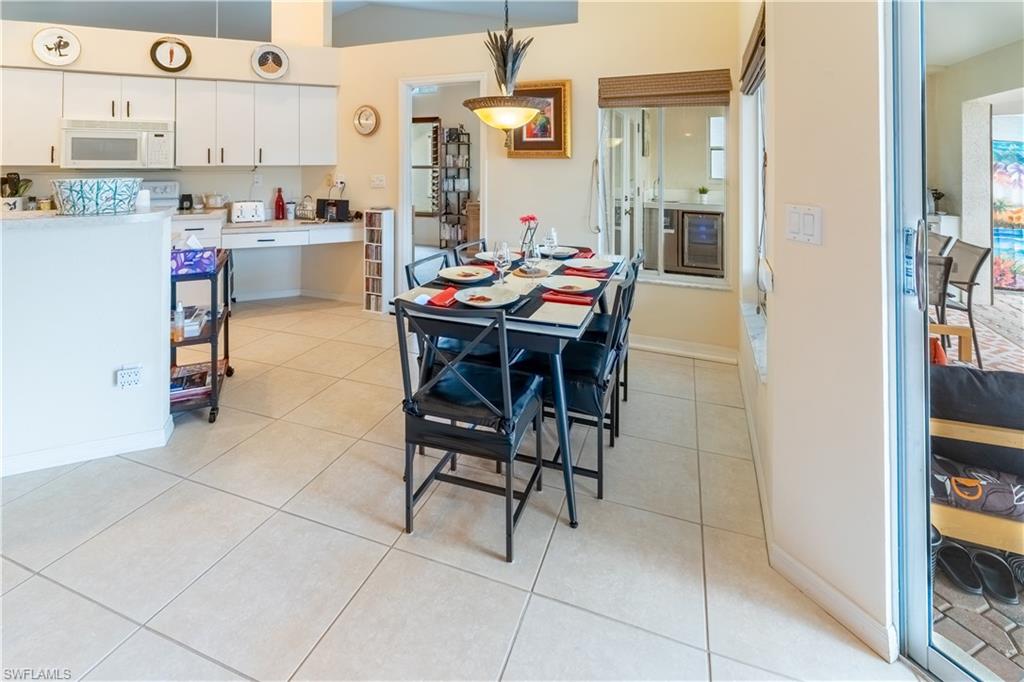 Dining space with light tile patterned floors and wine cooler
