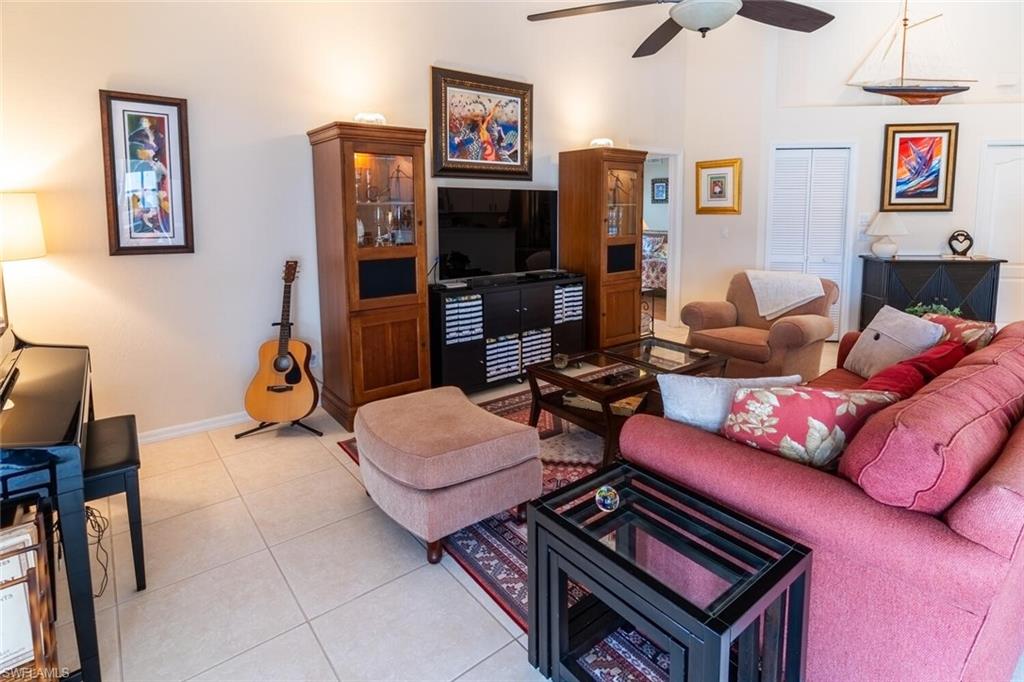 Living room with light tile patterned floors and ceiling fan