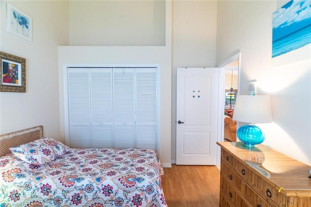 Bedroom with light wood-style flooring and a towering ceiling