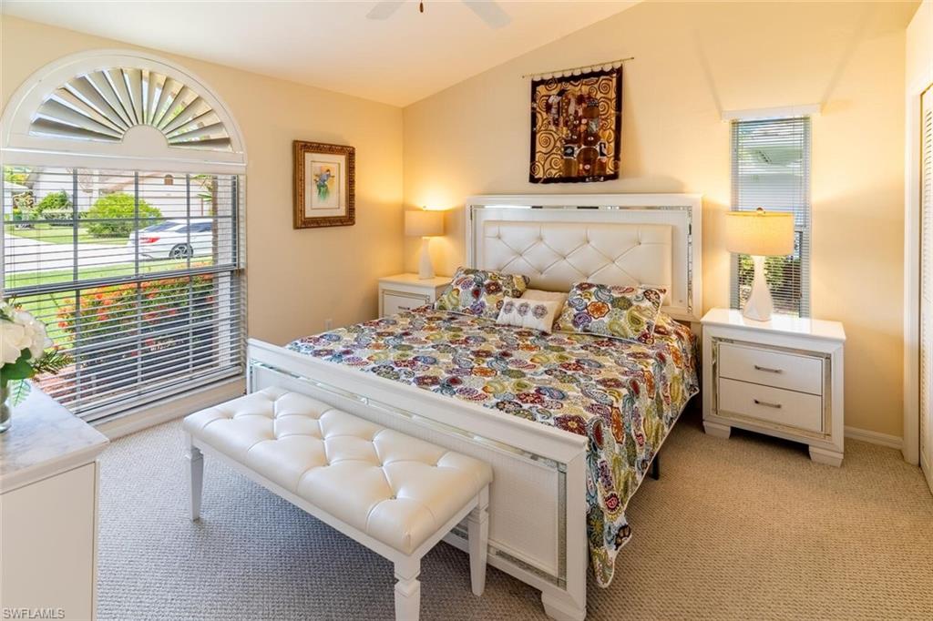 Bedroom featuring light carpet, lofted ceiling, and ceiling fan