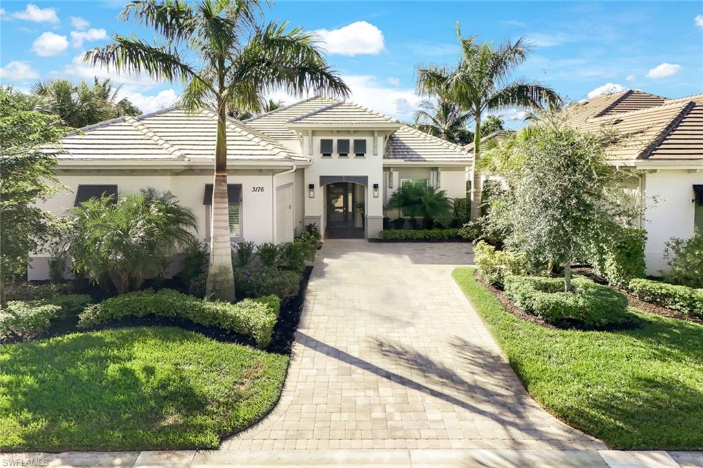 Contemporary single-story residence featuring a tile roof and a paver driveway
