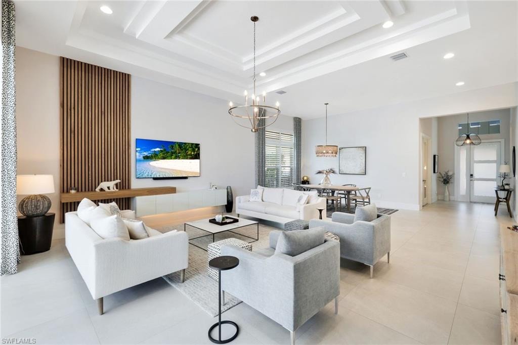 Spacious living area featuring coffered ceilings, recessed lighting, and large format tile flooring