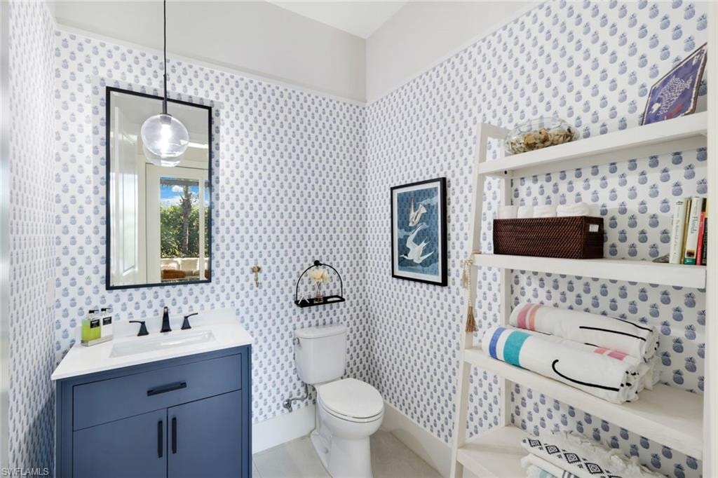 Powder room featuring a blue vanity with a white countertop and rectangular undermount sink, matte black faucet, and a contemporary pendant light fixture