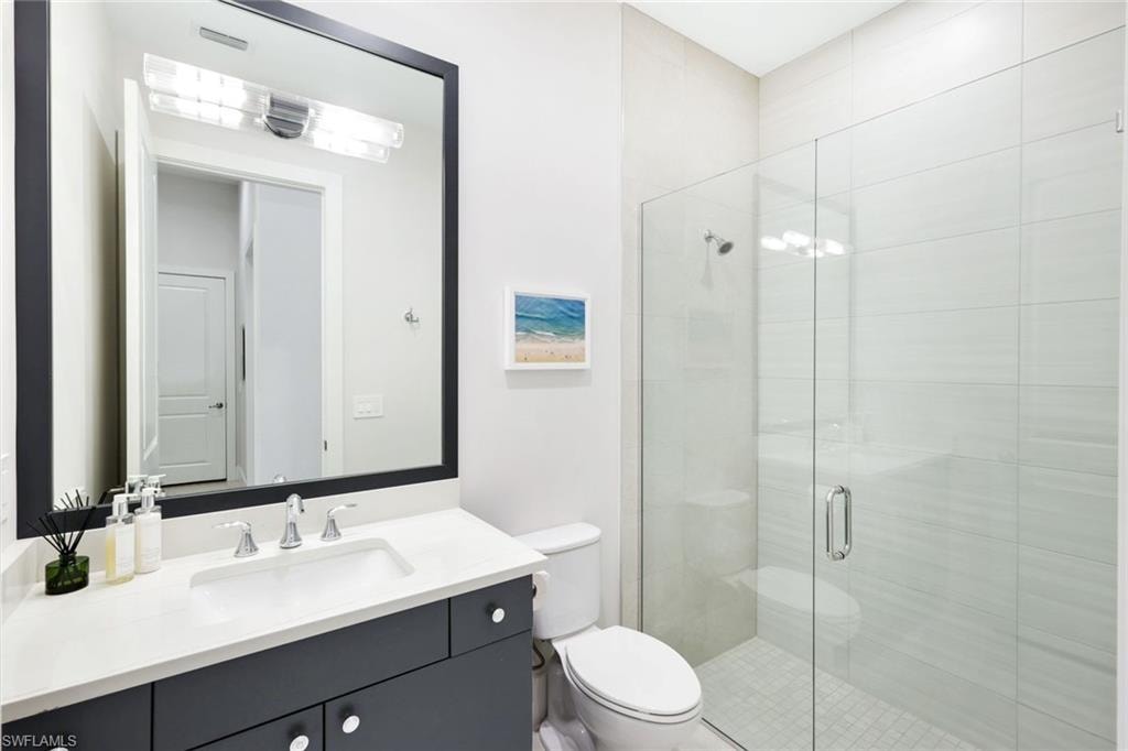 Contemporary bathroom featuring a dark vanity with a white countertop and an integrated sink