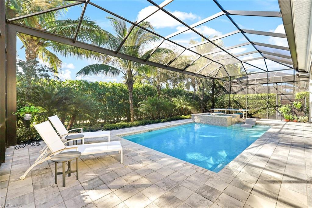 Screened outdoor area featuring a rectangular pool with an integrated spa