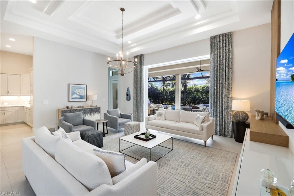 Spacious living area featuring a coffered ceiling, large format tile flooring, and a contemporary chandelier