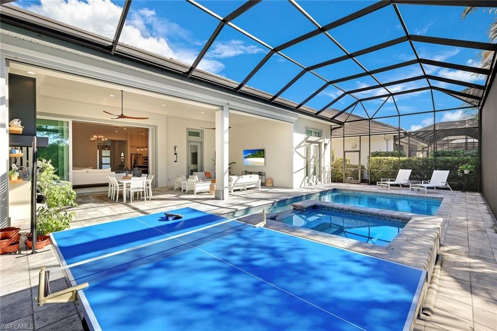 Screened lanai featuring a swimming pool, integrated spa, and expansive paver patio